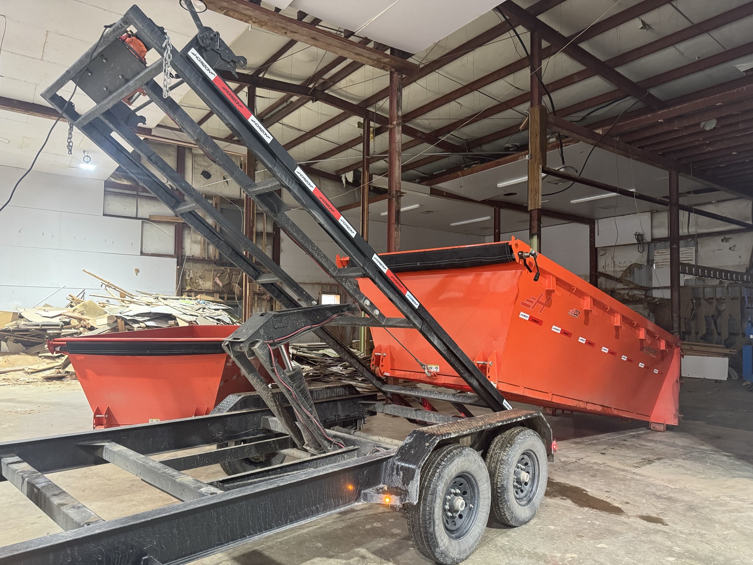 Triple G roll-off dumpster being loaded onto trailer